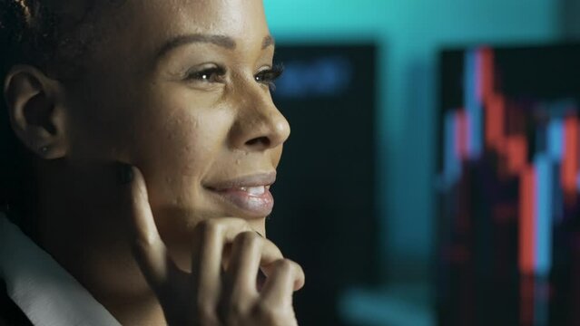 Close up shot of female working at office. African american business woman looking at monitor, analyzing data on screen, positive smiling face expression.