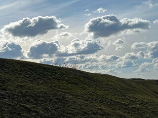 Amazing clouds in the sky above field.