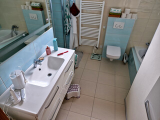 designer bathroom with glossy turquoise tiles. green and white combination even on a striped towel...