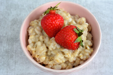 porridge in the bowl with strawberry top view close up