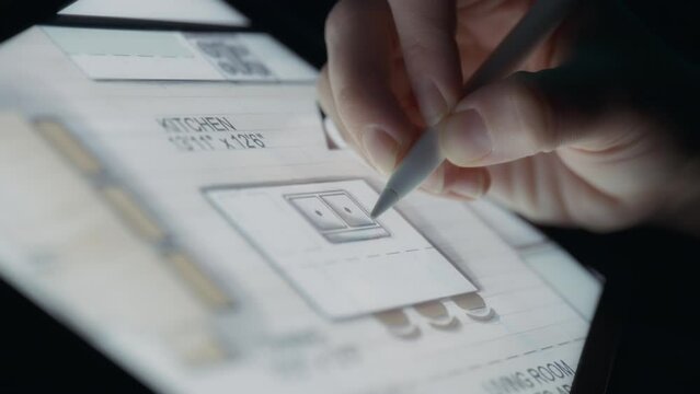 Interior designer rendering a kitchen layout on a tablet using a pen. Close up, slow motion.