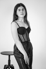 Beautiful young girl in black pants and a black bodysuit on a white background