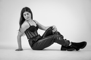 Beautiful young girl in black pants and a black bodysuit on a white background
