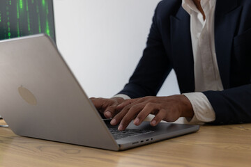 Asian male hacker hacking data at night in the dark