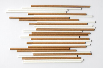 Top view of brown and whie straws on the white background