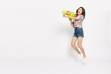 Young Asian woman in summer outfits jumping and holding water guns plastic for Songkran festival in Thailand isolated on white background - 737281208