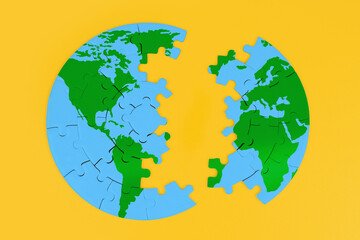 Globe Puzzle Split into Two Parts on Yellow
