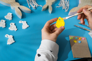 Master class of coloring Creator is using white air dry clay for making decor to EASTER holiday. Creating hobby recreation activity that involves fingers. DIY crafting Modern art 