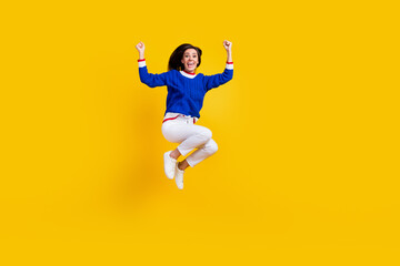 Fototapeta na wymiar Full body length photo of successful lady raised fists up jumping trampoline raise fists up big victory isolated on yellow color background