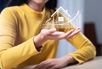Woman touches virtual house icon to analyze home loan and real estate mortgage insurance interest...