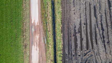 Extended Description: This aerial image presents a striking visual contrast between the lush green...