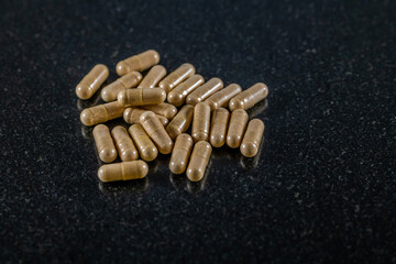 A close up view of Pygeum Africanum capsules on a dark marble platter