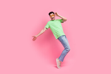 Fototapeta na wymiar Full length photo of funny guy dancing carefree standing tiptoes touching sunglass at summer party isolated on pink color background