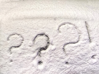 Three question and exclamation marks written in the snow. The cold frosty texture of the snow and the question mark. Background, place for text, copy space