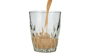 A stream of Irish cream liqueur is poured into a glass glass with ice.