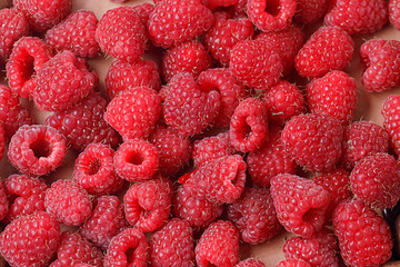 Background of fresh sweet red raspberries arranged together representing concept of healthy diet. Close up.