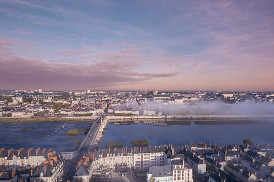 Serpentine Symphony: A Captivating Aerial View of Blois, Where a Majestic River Meanders Through a Thriving Cityscape.