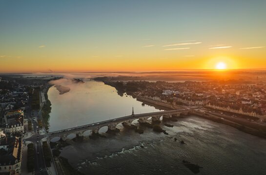 Golden Serenity: Captivating Aerial View of a Sunset River and Bridge