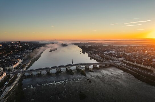 Golden Serenity: Awe-Inspiring Aerial View of Sunset Over River and Majestic Bridge in Blois, France