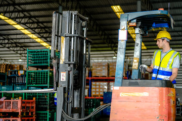 factory man driving forklift car working in distribution warehouse. factory worker teammates working beside stacks of cargo. Group of Diversity engineer factory people meeting.
