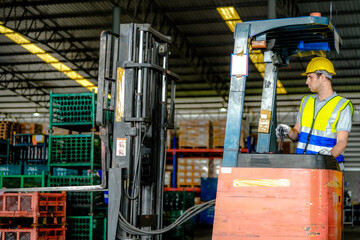 factory man driving forklift car working in distribution warehouse. factory worker teammates working beside stacks of cargo. Group of Diversity engineer factory people meeting.