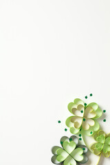 Four leaf clover paper art with confetti on white vertical background. St Patrick's Day concept....