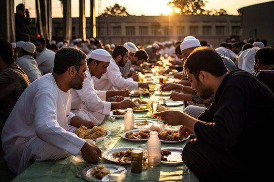 Muslim men breaking their fast during Ramadan by sitting around a table and enjoying a meal together.