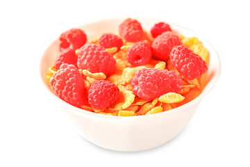 Delicious corn flakes with raspberries on a white wooden background. Fresh healthy food.
