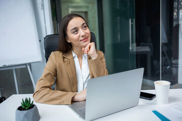 Young business woman worker relax sit at office desk with laptop computer dreaming chill at work