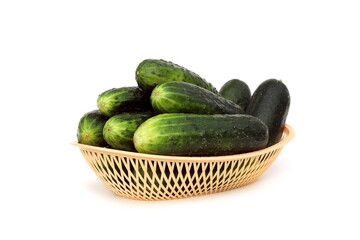 There is a basket with fresh cucumbers on a white background.