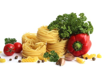 Pasta in the form of a nest with vegetables and herbs lies on a white background