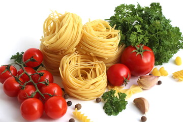 Pasta in the form of a nest with vegetables and herbs lies on a white background.	
