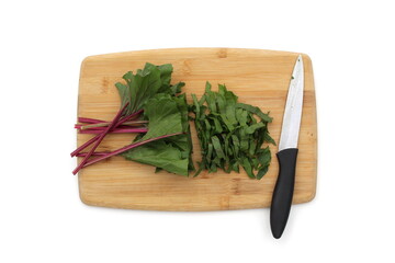 On a white background lies a wooden cutting board with chopped beet leaves.
