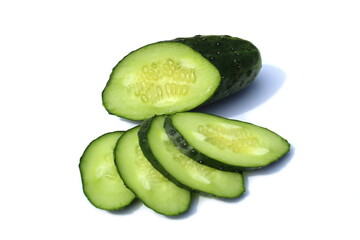 Many pieces of sliced cucumber lie on a white background.	
