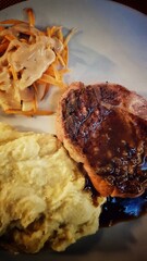 A photo of delicious sirloin pork steak dinner with garlic mashed potatoes and sauteed vegetables