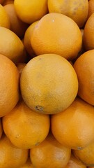Close up pile of tasty fresh oranges sold at the market as a background.