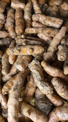 Close up pile of tasty fresh turmeric sold at the market as a background.