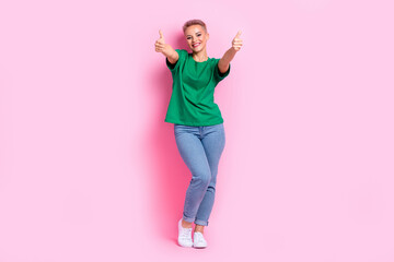 Full size photo of good mood pretty girl dressed green t-shirt jeans two hands showing you thumbs...