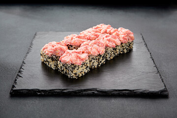 California roll in sesame seeds, topped with cream cheese and tobiko caviar; a classic roll with a creamy twist