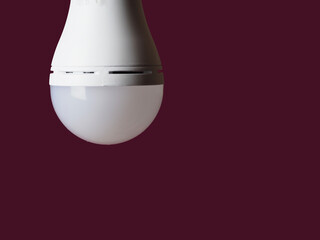 turned off LED rechargeable lamp on a burgundy background