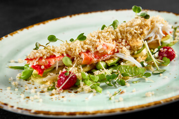 Salad with avocado, crab, and quinoa on a speckled turquoise plate