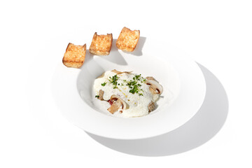 Creamy porcini mushroom soup with cheese espuma and croutons, elegantly presented