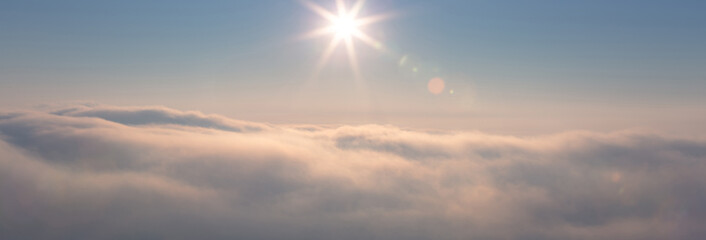Beautiful sky with shining sun over the clouds at sunrise time. Wide panorama. - 737383084
