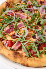 Gourmet tuna and olive pizza in nicoise style on a white background