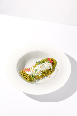 Pesto Pasta with Stracciatella Cheese Garnished with Pine Nuts and Edible Flowers, Perfect for Modern Italian Cuisine