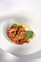 Braised beef with vegetables and mushrooms with a creamy mashed potato background, topped with shadow play for an enticing visual feast