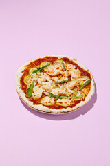 Gluten-free pizza with shrimp and zucchini on a pink background