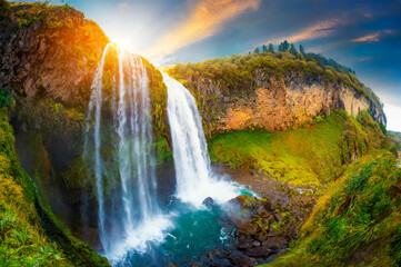 Realistic and impressive image of a wide-angle waterfall landscape. Waterfall at sunset.