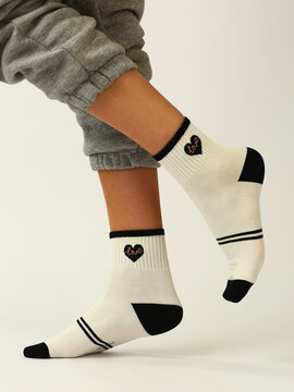 White Socks With Black Heart On Human Foot Close Up Photo On White Background