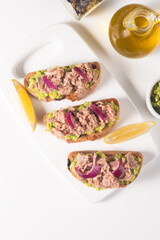 Toast with Canned Tuna. Fish open sandwich with avocado, red onion and lemon. 